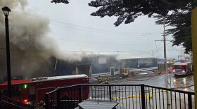 Firefighters pour water into the Pacific Seafood plant along SE Bay Boulevard in Newport Sunday morning after a fire broke out, releasing ammonia into the air and causing a partial roof collapse.
