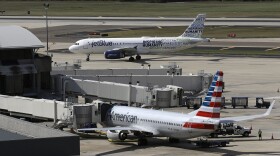 A JetBlue Airbus taxis to a gate as an American Airlines jet is seen parked at its gate at Tampa International Airport in Florida. (Chris O'Meara/AP)