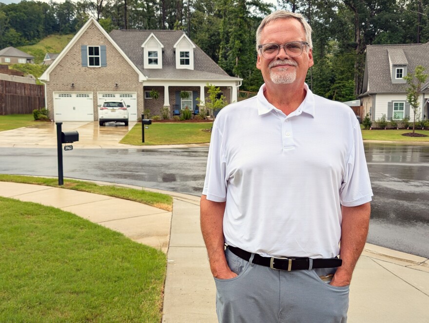 John Hilley stands in front of his home.