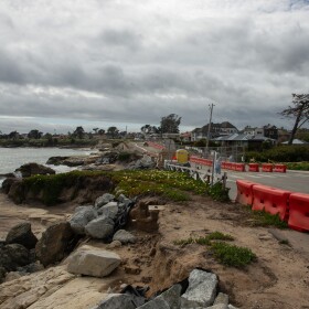 Orange barriers line part of the road next to the ocean on West Cliff Drive.