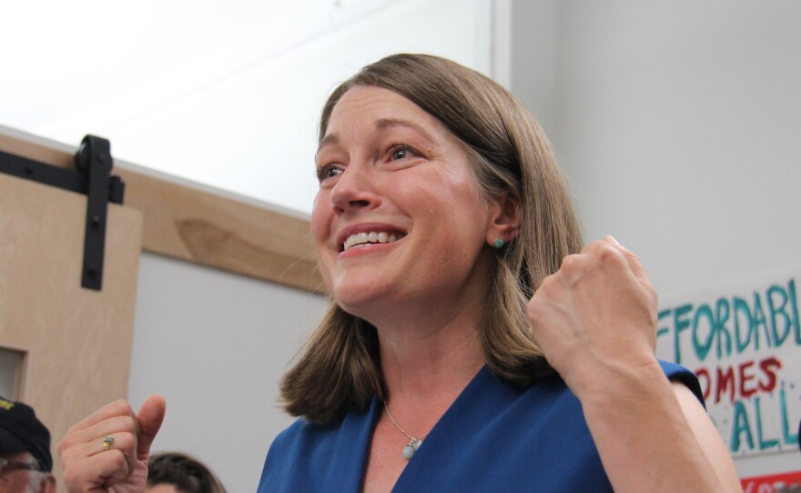A woman smiles and gestures 