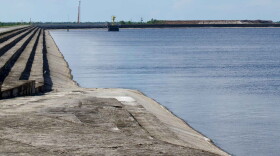  body of blue water to the right of a long bank of grayish sand, much of set up in stairlike levels 