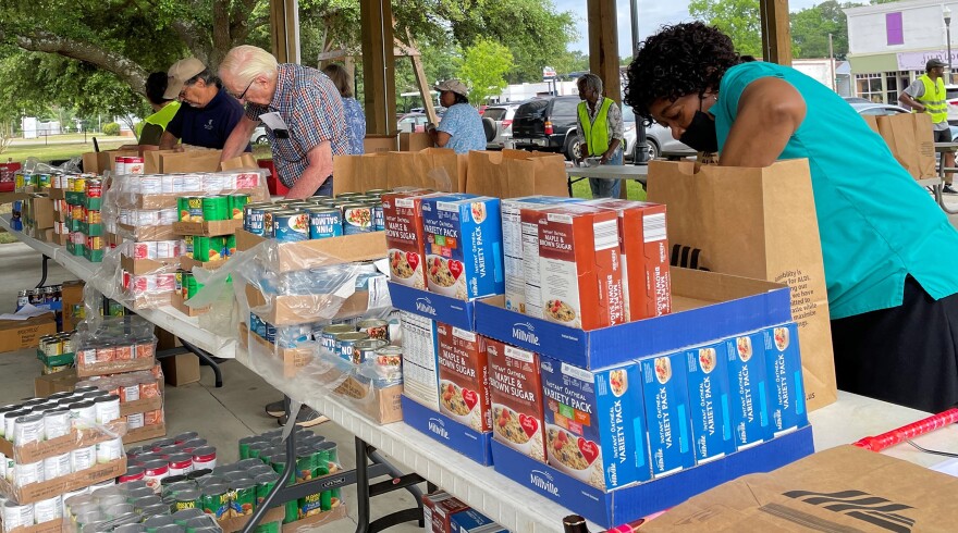  Sarah Coleman, right, with her trusty cane, sometimes shows up to collect food to help out. Other times, she takes part in ACTS's monthly distribution in Ridge Spring in order to give something back to neighbors who need a hand.