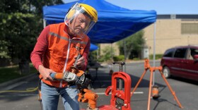 A volunteer uses an angle grinder on Saturday, May 31, at Myers Park Presbyterian Church to cut through a handgun that will be repurposed into a gardening tool as part of the Guns to Gardens initiative.