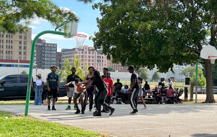 Teens play basketball at Loretta Hall Park in Carr Square