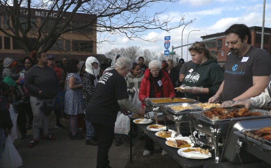 People in line next to a table of food containers