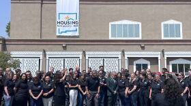 Staff of what was once known as the New Mexico Mortgage Finance Authority pose in front of their new logo and name, Housing New Mexico, after a news conference on Wednesday in Albuquerque. A legislative committee on Thursday endorsed proposed legislation to give Housing New Mexico $500 million to stem the state’s housing crisis.