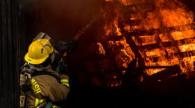 A firefighter tackles a practice blaze set inside a shipping container. 