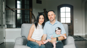Parents Kevin Stone and Angie Koriakos sit with daughter Eliana Stone in their home in Dallas on Aug. 26, 2026. Eliana was born via a surrogate.