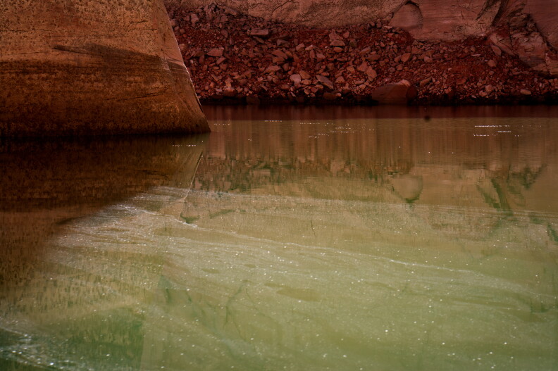 Water sparkles on a shrinking Lake Powell near the Cathedral in the Desert in Glen Canyon.