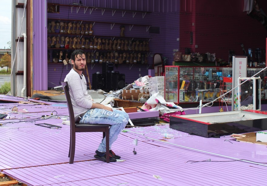 Mahdi Ali sits outside his family's beauty supply store in Lake Charles, Louisiana on Aug. 28, 2020. The building is severely damaged and tens of thousands of dollars in merchandise is missing or damaged.