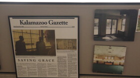 A newspaper clipping along with photos of what the church looked like before the renovations hang on the side of a desk. The tagline "Saving Grace" can be seen on the newspaper, which is framed along with the two photos.