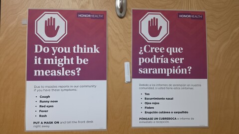 A sign asking about measles symptoms on a hospital door.