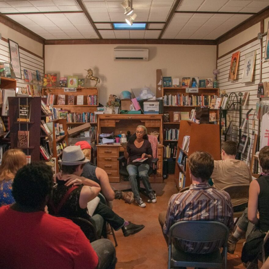 Erica Merrell, co-owner of Wild Iris Books, speaks to the crowd gathered for one of the bookstore's bi-monthly queer feminist open mics. The store has been changing its programming to become more focused on inclusivity since Erica took charge in 2009, recently changing the name from simply feminist open mics to queer feminist open mics. Photo courtesy of Yatrik Solanki.