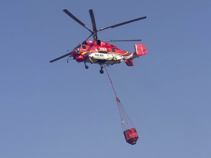 In this photo released by Xinhua News Agency, a helicopter leaves to fight a forest fire in China's Sichuan Province.