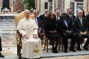 A group of people in suits sit with the Pope in chairs