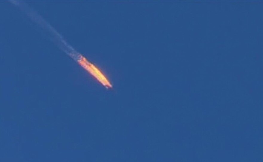This frame grab from video by Haberturk TV shows a Russian warplane on fire before crashing on a hill as seen from Hatay province, Turkey, on Tuesday.