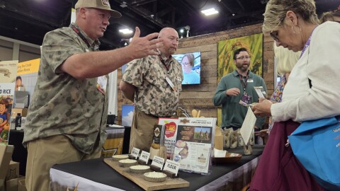 Tommy Wheeler, founder and owner of Tidewater Grains, speaks with school nutrition professionals about his company's rice products at the Charlotte Convention Center.