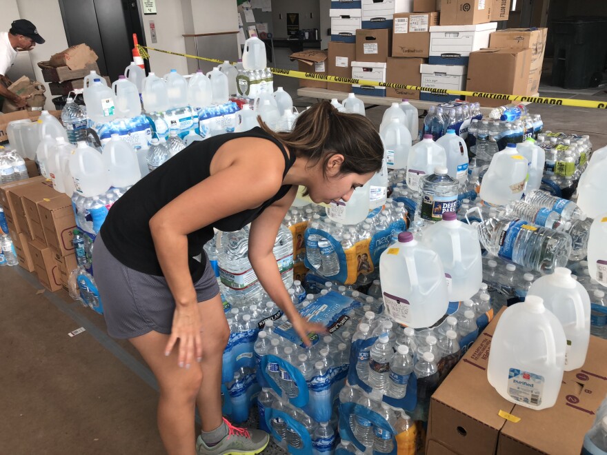 Volunteer Andy Gardiner organizes bottles of water at the TAC Air private airport terminal during "Operation Airdrop" earlier this week. 