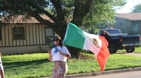ACU student Eva Carrillo carries the Mexican Flag in the parade.