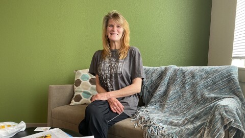 Alison Perkins, 51, sits on the new couch in her apartment at Mason Place. Perkins lived on the streets for two years before moving into the building in March.