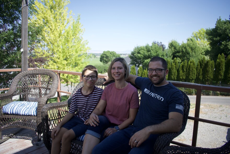 Nathan Ruben, his wife Sarah Ruben, and their son Hyrum Ruben sit on the back deck of a renovated home in Hyde Park, Utah, on July 15, 2025. The Rubens partnered with Utah State University’s Veterans Resource Office to turn the previously vacant house into housing for student veterans.