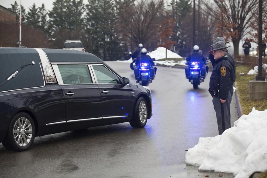 Virginia State Police salute as a hearse passes with the bodies of Bridgewater College police officer John E. Painter and college safety officer J.J. Jefferson in Roanoke.