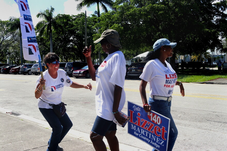 Lourdes Pons (left to right), Alease Dix and Mory Pedroso dance in front of the South Dade Regional Library on Sunday, August 26, during "Souls to the Polls."