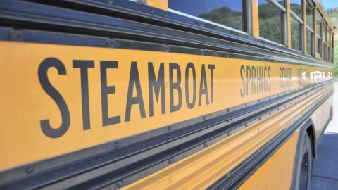 A close up of a yellow school bus for the Steamboat Springs School Distrcit