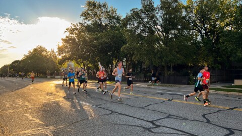 A group of marathoners and half-marathoners runs alongside a pacer — a runner running a predetermined pace — west on Douglas. The 2025 Prairie Fire Marathon route took runners through College Hill and back again.