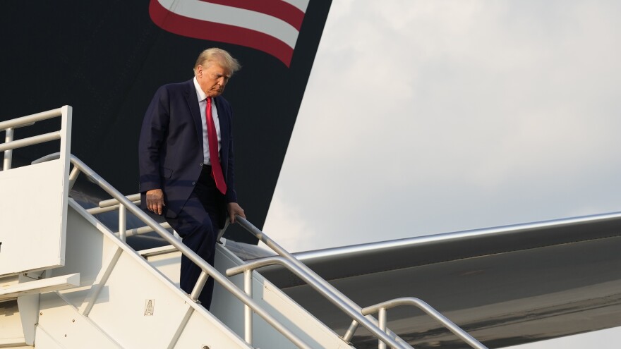 Former President Donald Trump steps off his plane as he arrives at Hartsfield-Jackson Atlanta International Airport on Thursday. Trump was then booked on 13 Georgia felony charges.