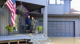 Locke and Melissa Brown stand on the porch of their home that was flooded on Meander Way on Wednesday, Aug. 13, 2025.
