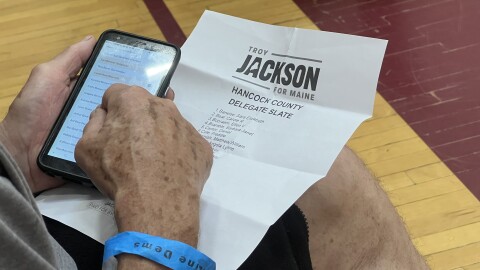 A Democratic voter in Ellsworth consults Troy Jackson's list of supportive delegates on July 18, 2026, as he uses a mobile app to select his preferences for who should represent Hancock County at the Democratic nominating convention on July 25.