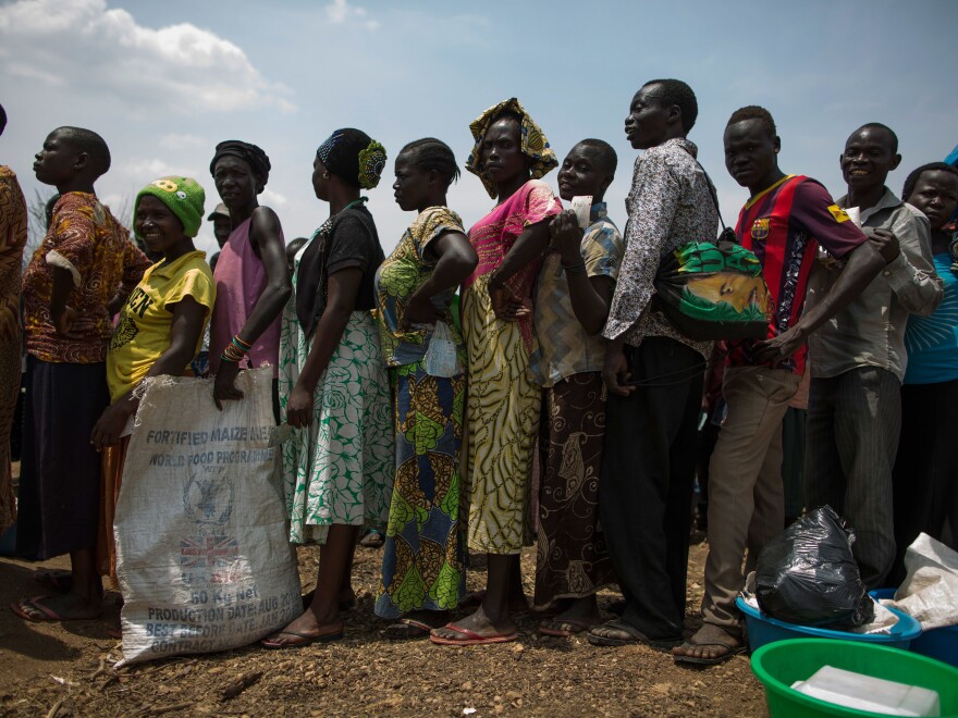 Families wait for a food aid delivery at Uganda's Bidi Bidi refugee camp in February. Bidi Bidi is home to more than 270,000 people who have fled South Sudan's civil war and is the biggest refugee camp in the world.