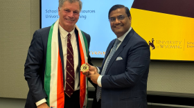 An older White man poses for a photo with an Indian man.