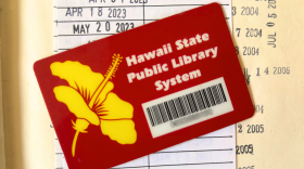 a state library card sits on the check-out record of a library book