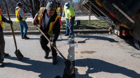 A work crew fills potholes on Perring Parkway in Baltimore. Crews filled at least 32,000 potholes from late February through mid-March, and the city aims to fill another 25,000 potholes by mid-July.