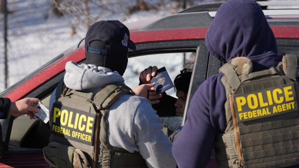 Federal agents make a traffic stop on a U.S. citizen as they provide their identification including a passport and drivers license, Tuesday, Jan. 27, 2026, in Minneapolis.
