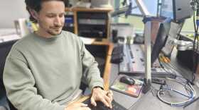 Health reporter Joe Mario Pedersen types out a records request in a Central Florida Public Media studio booth.