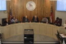 a group of people sitting at a meeting, a sign reading "City of Thomasville North Carolina" 