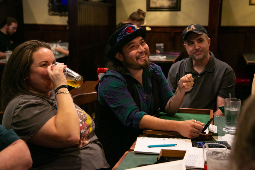 A group of people sitting around a table playing a game. 