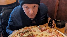 NEPM's Monte Belmonte poses with the pizza at Family Pizzeria Europa in Springfield, Mass.