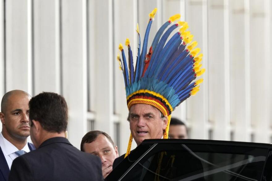 Brazilian President Jair Bolsonaro trying on an indigenous headdress in Brasilia this year.