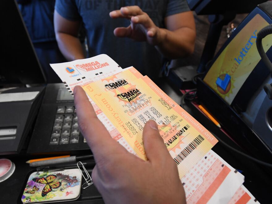 A man in Torrance, Calif., buys a Mega Millions ticket hours before the drawing on Friday evening. No one won that drawing, and the jackpot went up to $1.6 billion.