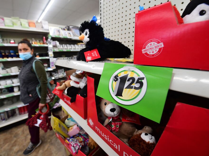 A shopper walks by a sign displaying a $1.25 price tag that was posted on the shelves of a Dollar Tree store in Alhambra, Calif., on Dec. 10, 2021.