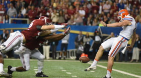 Alabama linebacker Keith Holcombe (42) extends his body to block Florida punter Johnny Townsend's (19) punt for a safety in the first half. (Greenberry Taylor/ WUFT News)