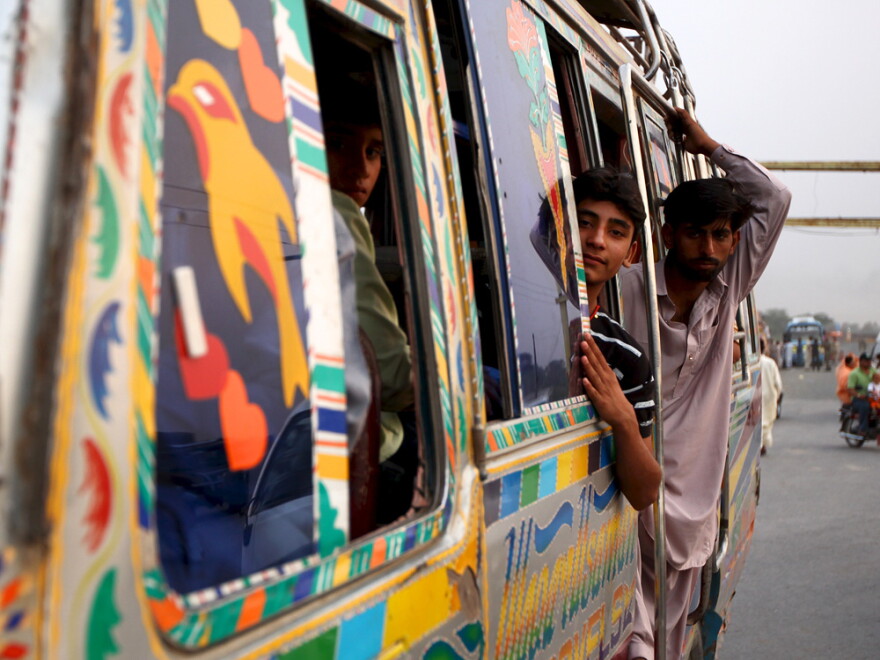 Young men ride a bus home after watching the military spectacle of the Wagah border ceremony.