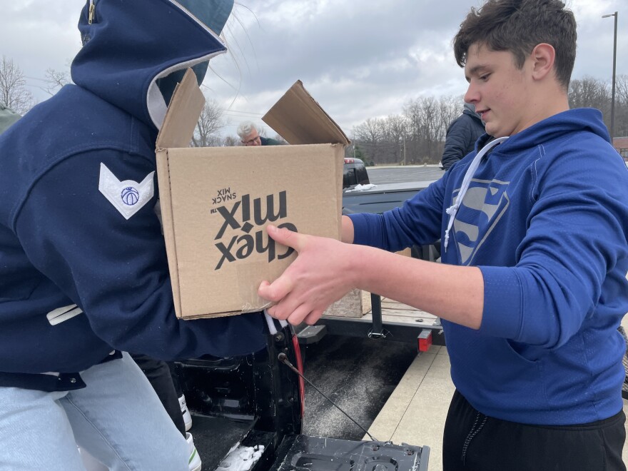 Eighth grader Bradyn Lothamer hands off a box full of food to be loaded onto a truck and driven to the churches on Tuesday, November 17, 2022. Lothamer earned the most points of any individual at Carroll Middle by bringing in the most food.