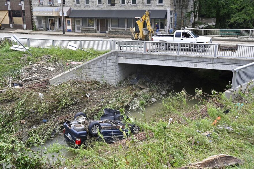 A car lays overturned in Troublesome Creek in downtown Hindman, Ky., Sunday, July 31, 2022. (AP Photo/Timothy D. Easley)