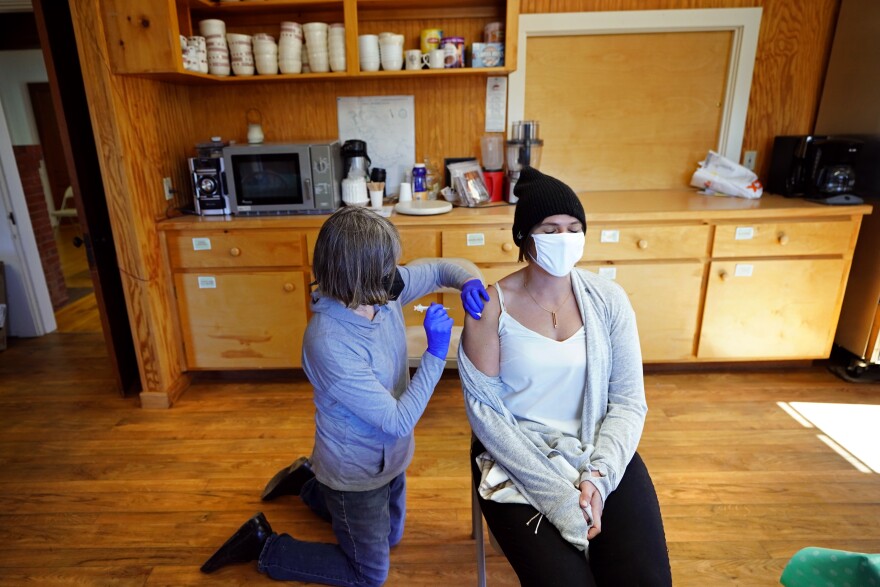 Nurse Sharon Daley, administers a COVID-19 vaccination to Hollie Stanley in a makeshift clinic in the kitchen of a community center, Friday, March 19, 2021, on Great Cranberry Island, Maine. (AP Photo/Robert F. Bukaty)